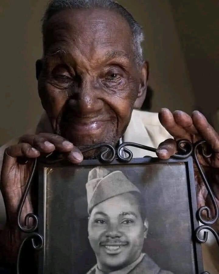 Lawrence Brooks - Oldest WWII veteran aged 110 holding a photo of himself.