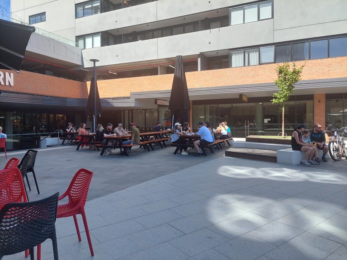 HowardFMaclean's tweet photo. One of the weirdest things about Australian urbanism discourse is the argument that tall buildings create shaded public spaces, and this is bad. But on this 36C past Sunday, the fact that Eyre Street market's forecourt is sheltered from the sun was a big draw. #Canberra https://t.co/0m6k2a1q17