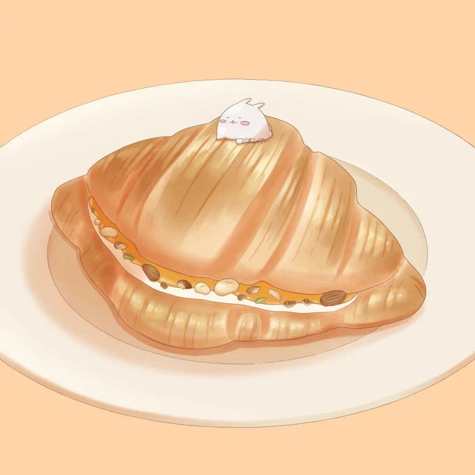 キャラメルナッツのクロワッサンの上でのんびりしているまるまるつるっとしたうさぎ 