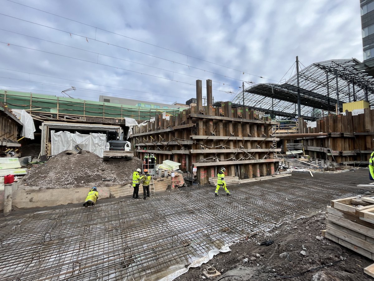 Aukko keskellä Helsingin päärautatieaseman raiteita! Joulukuussa 2023 vaikutukset junien pysähtymisiin ovat ohi ja helmikuussa 2024 tästä pyöräillään. Vasemmalla (ja selän takana) Kaisantunneli ja oikealla tuleva yhteystunneli nykyiseen jalankulkutunneliin. Tiivistä yhteistyötä.