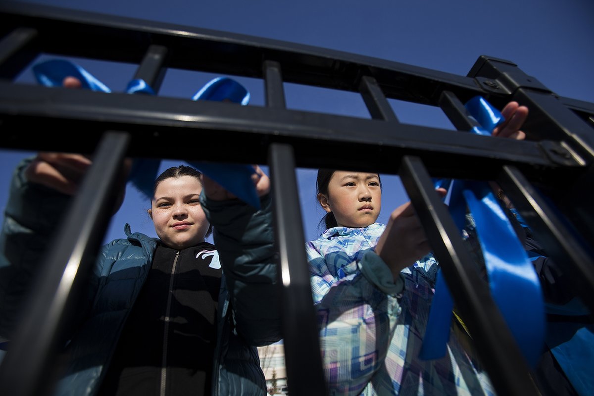 davidbloomphoto's tweet image. Grade 4 students at Const. Woodall School tie blue ribbons on a fence outside of the school in memory of Const. Travis Jordan and Const. Brett Ryan. Students have also posted heart shaped messages of support for police officers on a wall inside the school. #yeg @EPSBNews