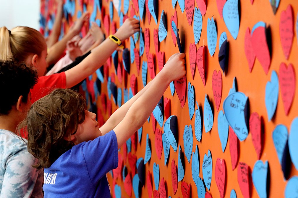 davidbloomphoto's tweet image. Grade 4 students at Const. Woodall School tie blue ribbons on a fence outside of the school in memory of Const. Travis Jordan and Const. Brett Ryan. Students have also posted heart shaped messages of support for police officers on a wall inside the school. #yeg @EPSBNews