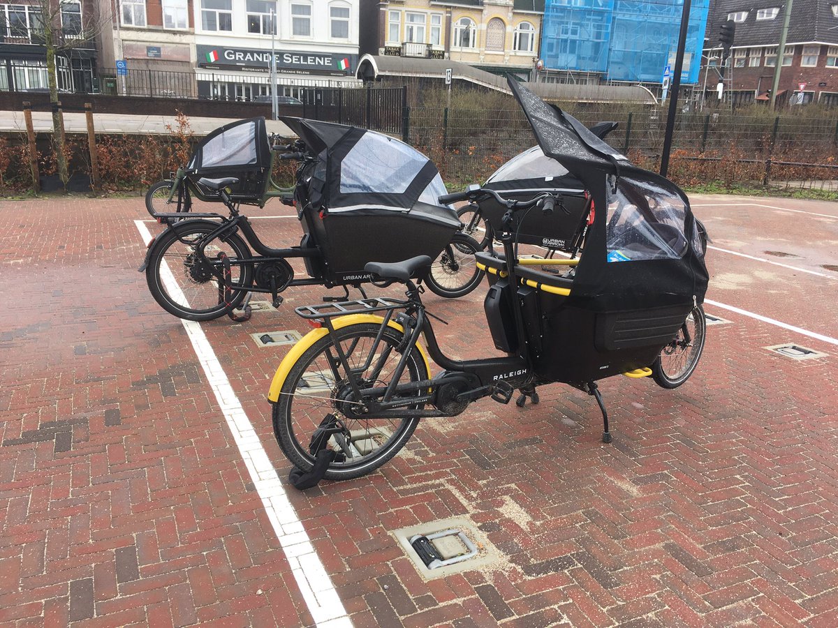 ActiveUrbanist's tweet photo. Simple solution for cargo bike parking… a small ring in ground that lifts. Also works for mopeds. This at a train station, would also work in supermarkets, car parks, local shops etc. https://t.co/EttvcViZNZ