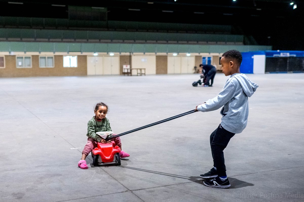 Kinderen spelen in grote hal van de crisisnoodopvang in het Fries Congrescentrum van Drachten.