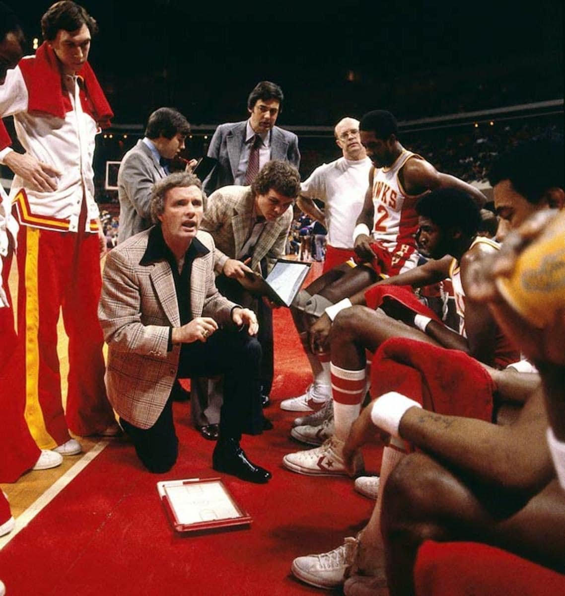 Hubie Brown addressing his Hawks team in the huddle, with assistant coach Mike Fratello looking on.