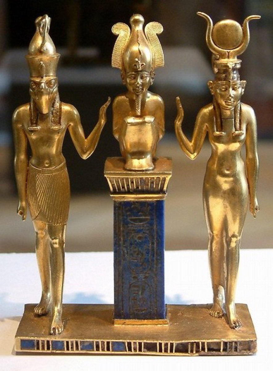 Antiguo colgante egipcio (oro, lapislázuli y cristal rojo), que representa a la familia divina de Osiris, Isis y Horus. En el pilar que sostiene a Osiris se encuentra el cartucho del faraón Osorkon II de la Dinastía XXII (reinó 872-837 a.C.). Ahora en el Louvre.
