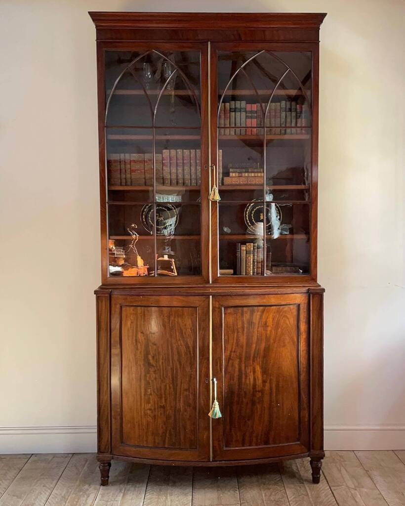 New in: Fine quality early 19th century mahogany bookcase cabinet. Moulded cornice over a pair of astragal glazed doors enclosing four adjustable shelves. Bowfronted base section, with two finely figured frame and panel doors enclosing two adjustable she… instagr.am/p/CqNmFHKIkWF/
