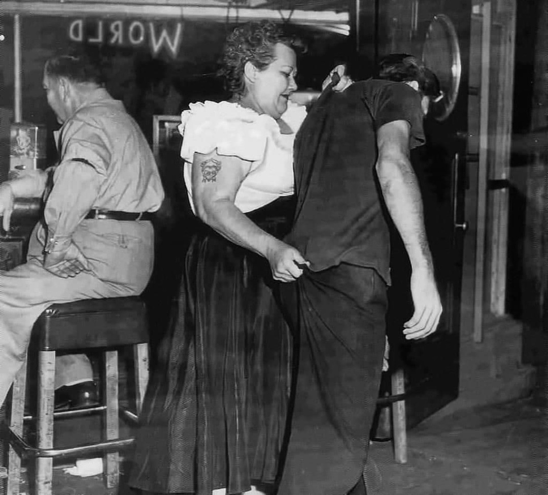1953: Cairo Mary, a bouncer at Shanghai Reds (5th and Beacon in San Pedro) escorts a customer to the door.