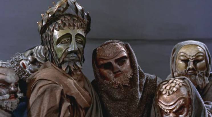 Thinking about the '57 Oedipus Rex film by Tyrone Guthrie, I admire the strange distance placed between the viewer and narrative by putting the entire cast in heavy robes and beneath those Greek theater masks.
A surreal artifice closer to puppetry than drama.