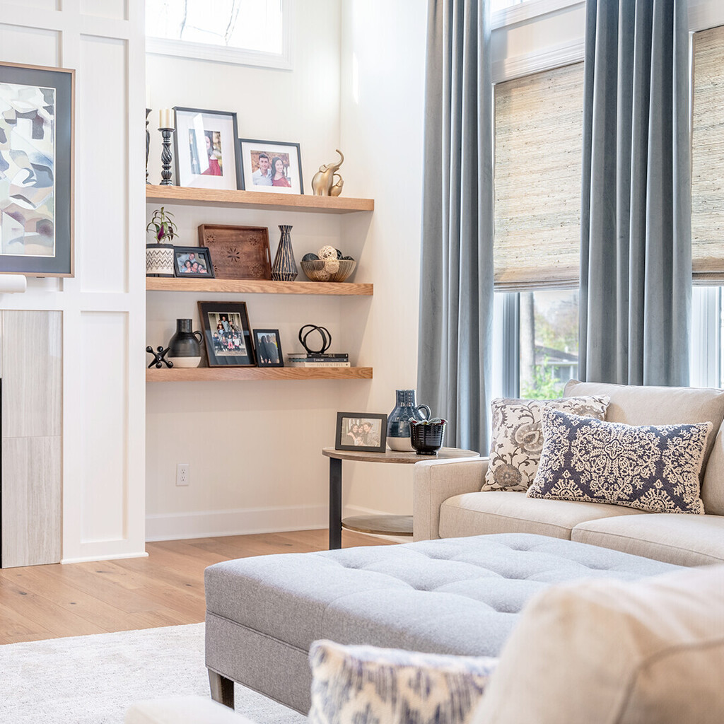 By layering window coverings, you can give your windows a touch of style and versatility. Here, they provide a counterpoint to the lighter elements in this living room, which incorporates woven wood shades and drapery to complement the wood grain flooring.
