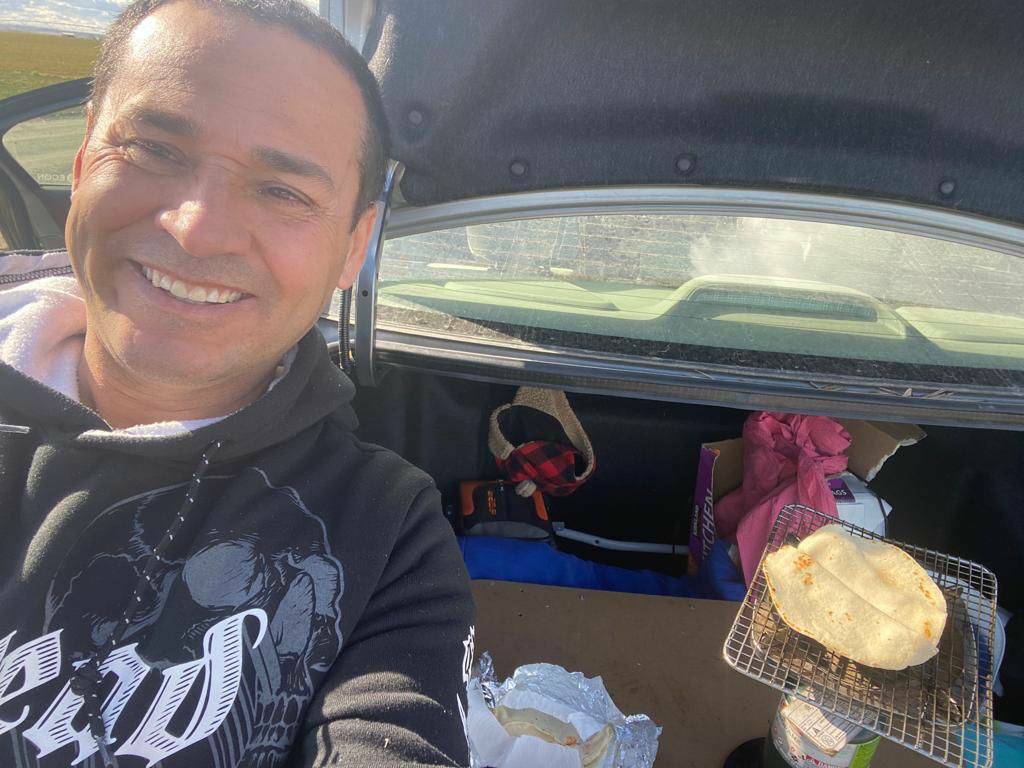 UFWupdates's tweet photo. Joaquin was heating up his lunch in the trunk of his car. In the fields there is no lunch room, no heat or AC, no table or chairs, no shade, no microwave, no refrigerator. This is how the men and women who harvest America’s food eat their lunch. #WeFeedYou https://t.co/Wq7kfUYCAo