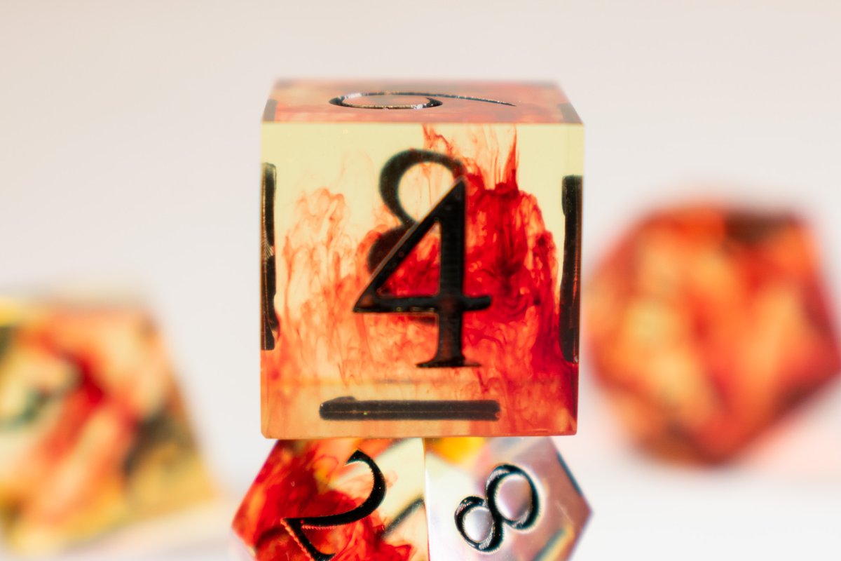 I saw a factory-made set with a yellow base and red swirls. And of course, as a dice maker, I immediately went, "I can do that." I'm pretty pleased with how this turned out. I haven't used black inking in a long time, but I thought it was perfect for this set. #handmadedice