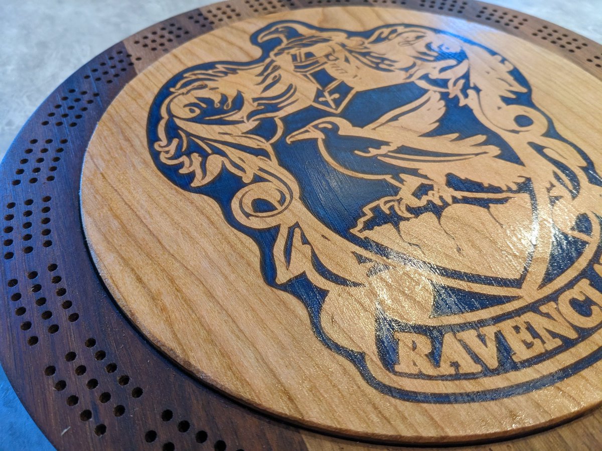 jmauser's tweet photo. Black walnut cribbage board with cherry lid and internal storage. Ravenclaw logo filled with blue mica in epoxy. https://t.co/ydnonFvBzv