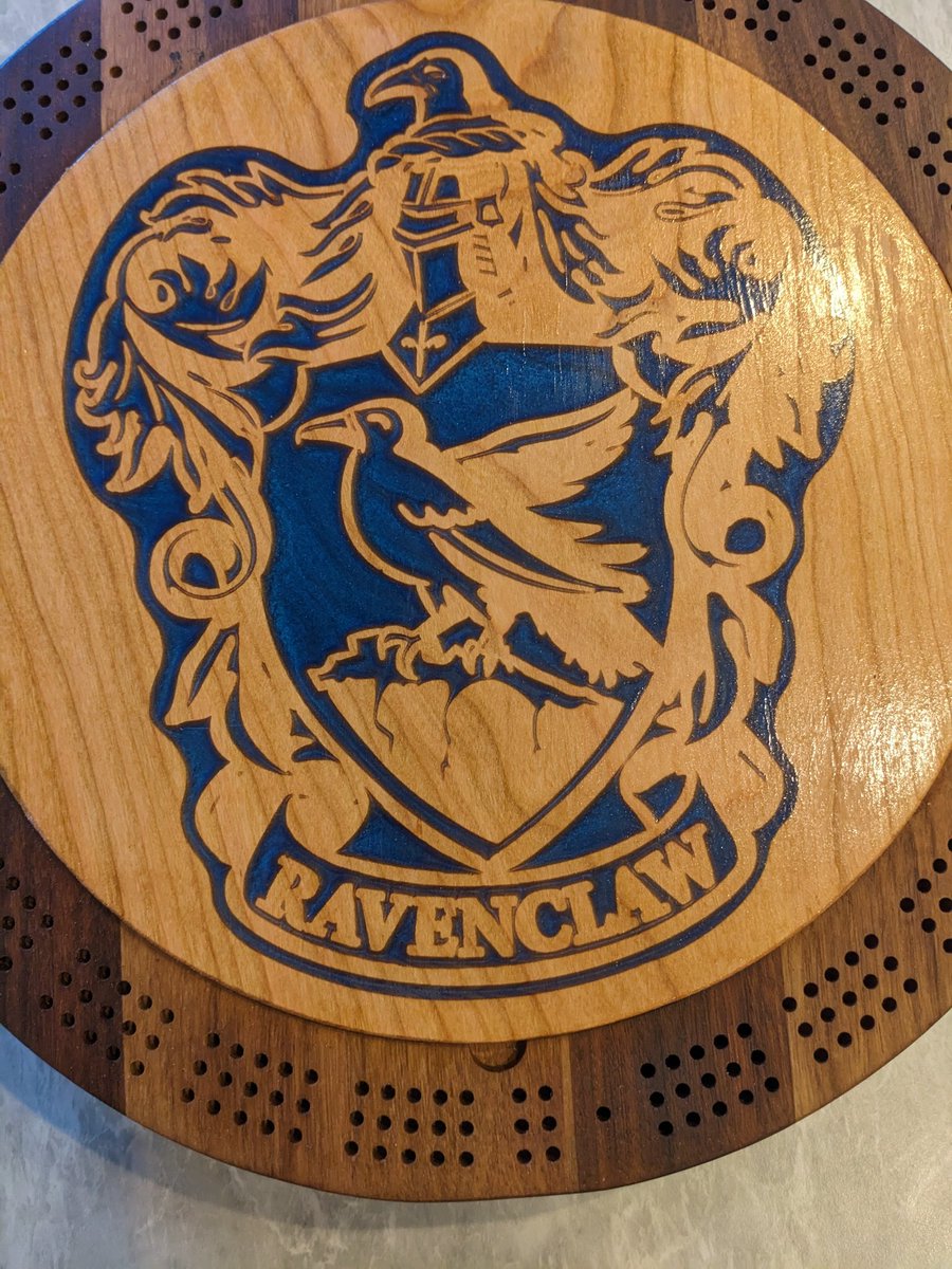 jmauser's tweet photo. Black walnut cribbage board with cherry lid and internal storage. Ravenclaw logo filled with blue mica in epoxy. https://t.co/ydnonFvBzv