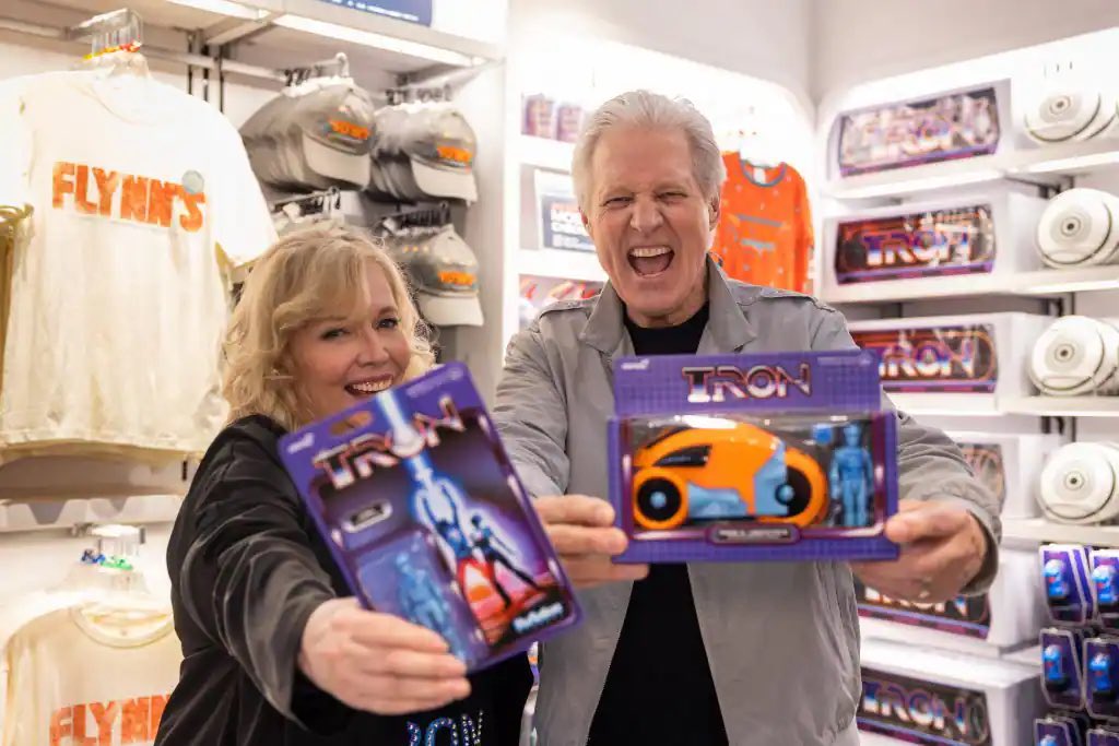 Cindy Morgan and Bruce Boxleitner holding TRON merchandise