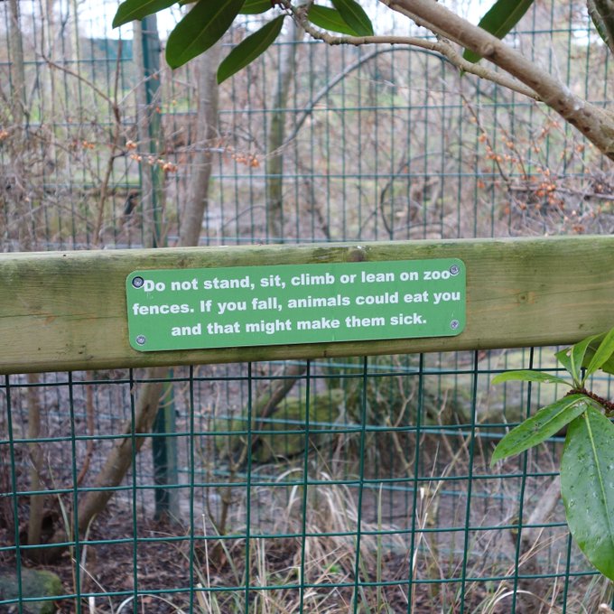 Sign on a fence: `Do not stand, sit, climb or lean on zoo fences. If you fall, animals could eat you and that might make them sick.`
