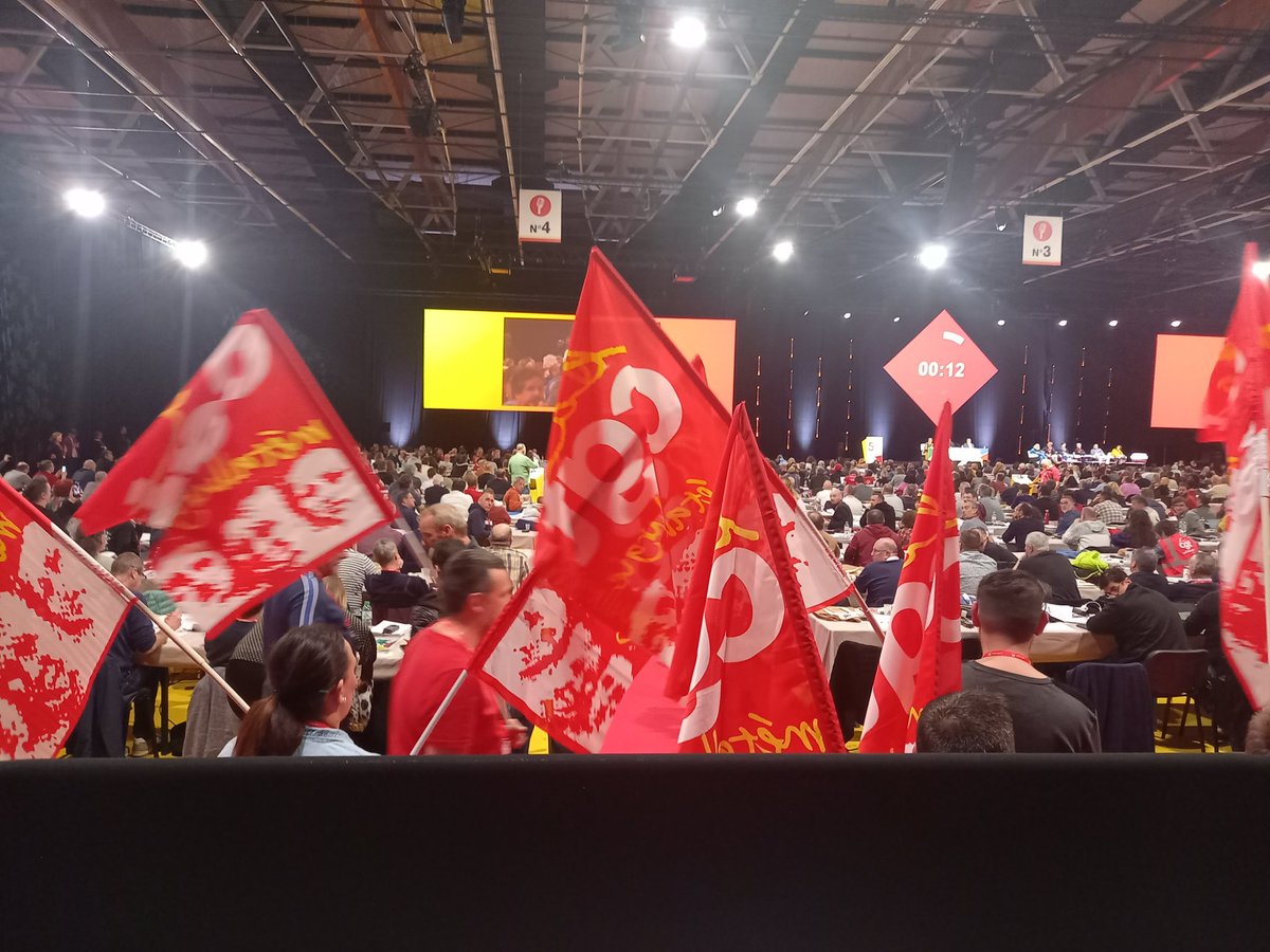 Des drapeaux de la CGT métallurgie devant la tribune presse pour empêcher les caméras de filmer pendant l'intervention d'Olivier Mateu (?)