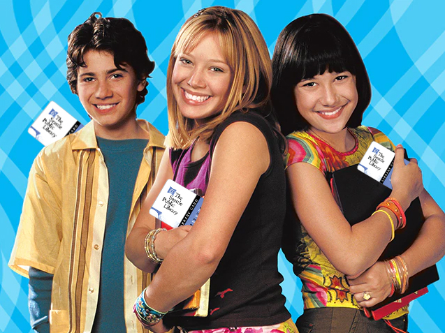 A photo of Lizzie, Miranda and Gordo from the Lizzie McGuire show. They look trendy and relatable in early 2000s outfits and are all holding Seattle Public Library cards.