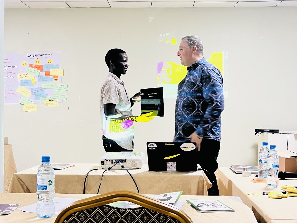 Anyanzo Jonathan receiving a book  from Steve Kovats, during the -#ASKnet co creation, the book contains a thesis that Basti made during his Masters that involved the hubs contribution in building a training tool!