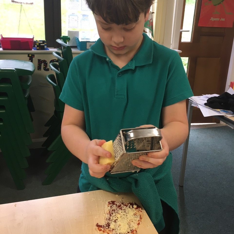 ysgolswnydon's tweet image. Awel enjoying their Baking Reward this morning.  Pizzas and cakes were on the menu! #righttrack