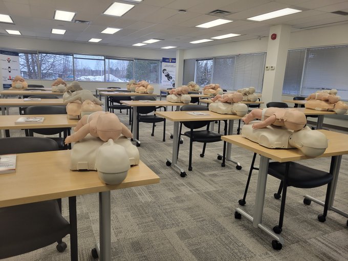 Teaching room with CPR trainers on the desks.