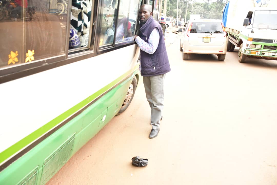 DailyMonitor's tweet photo. A female passenger forced to pick a polythene bag thrown outside a coaster in Kataza, Bugolobi in Kampala on April 1, 2023, the day NEMA had initially planned to start enforcing their directives on having dustbins in cars. 
#MonitorUpdates
📸 Stephen Otage https://t.co/ClQTfmLo36