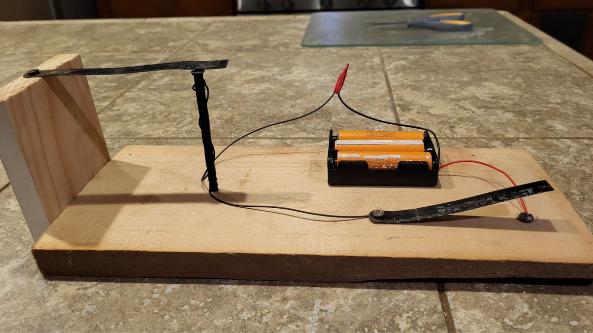Helped my oldest son build a #telegraph for his school #scienceproject.  Ain't pretty, but it works...and fun to use parts from my dad including old saw blade, nails/screws, wood, and batteries from an old laptop.  Kinda fun to make my first #cw key with a sawblade and screw! 😃