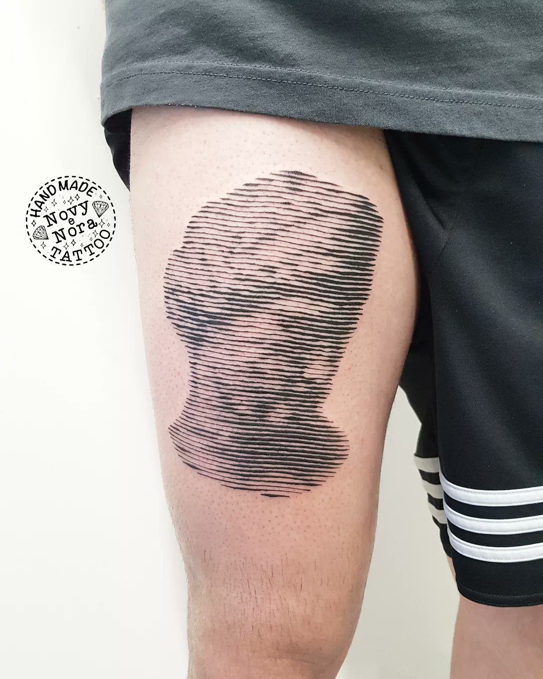 Halftone 'The First Kiss' tattoo located on the thigh.