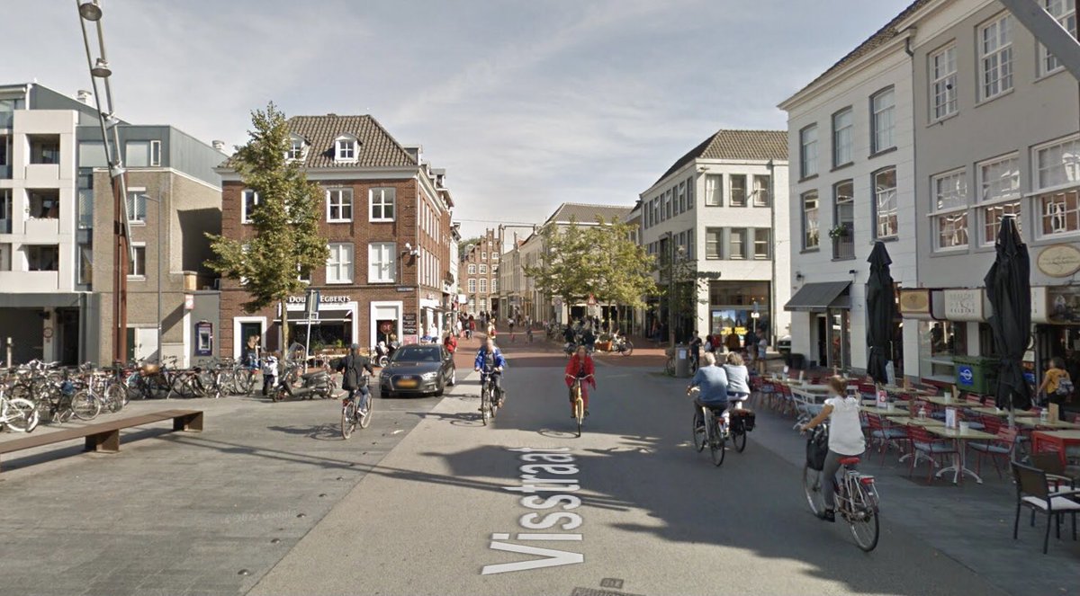 De Visstraat in Den Bosch. Links in april 1955 (afb. Erfgoed DB) Rechts in 2018. Het fabrieksgebouw van De Gruyter en op de achtergrond de toren van de Sint Pieterskerk zijn de overduidelijke ‘slachtoffers’ van de tijd. De bomen een groene aanwinst.