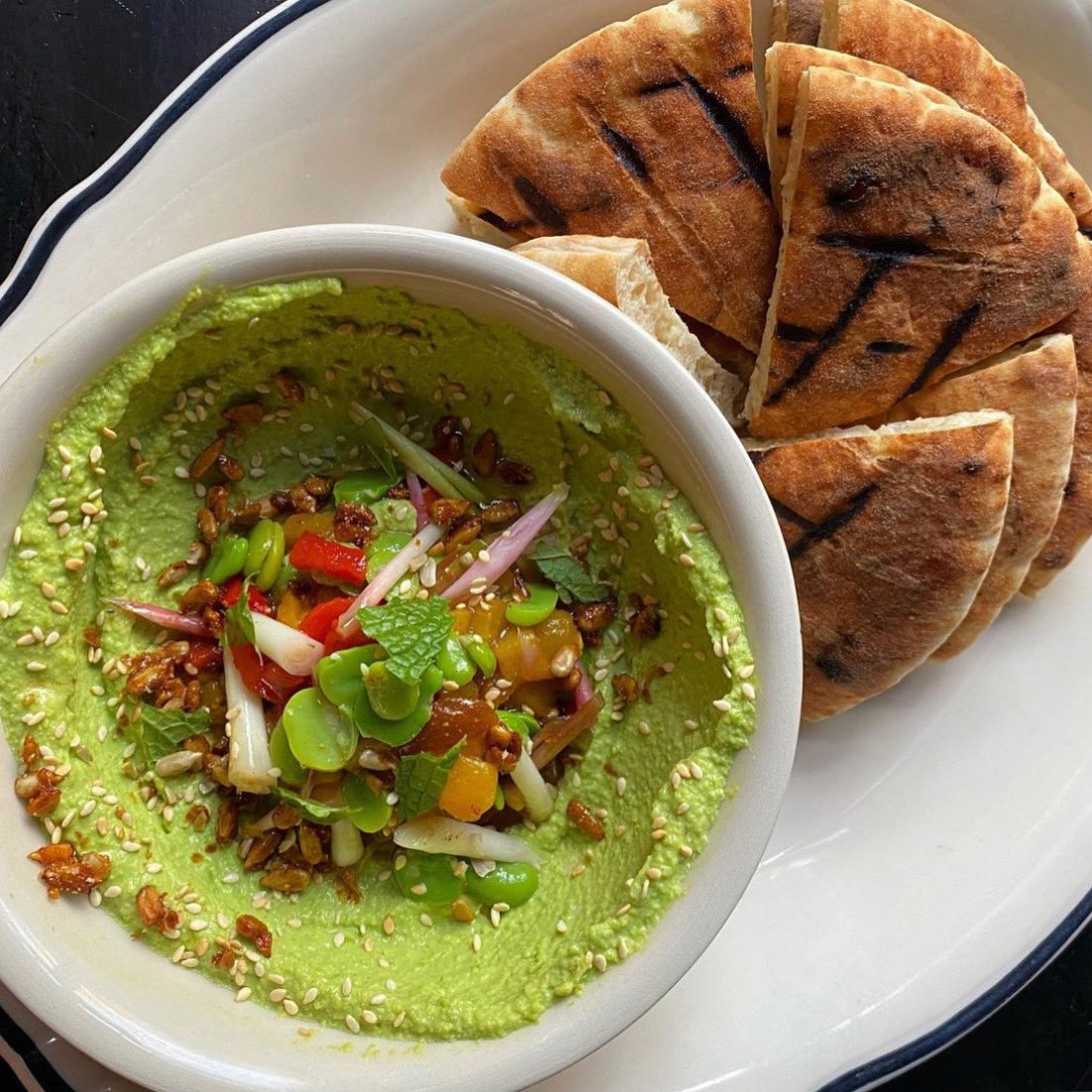 English Pea Hummus with pickled ramp &amp; pepper relish, fava beans, mint, toasted sesame, spiced sunflower seeds and grilled pita 🟢 budandmarilyns.com