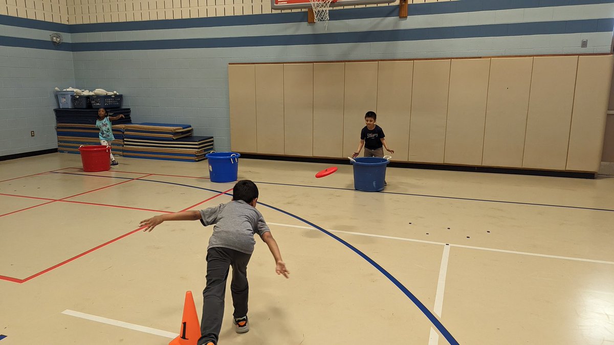 Students in @MrsAKeller's kindergarten class are learning how to throw and catch a frisbee. Thanks to <a href="/thepespecialist/">Ben Landers</a> for the station ideas: 1. Throw and catch w/ a partner, frisbee bowling, frisbee golf, and can jam. #physed #fvfoxes