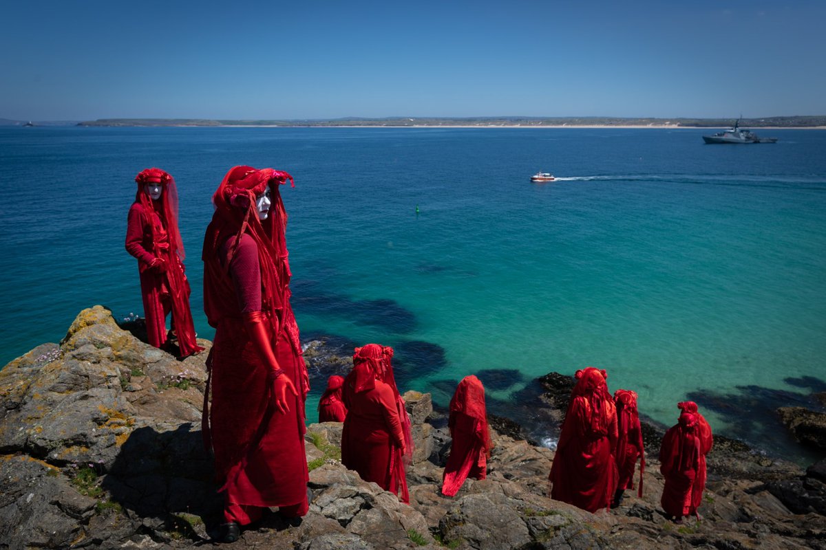 The #ExtinctionRebellion Red Rebel Brigade gather on a beach to #protest close to where the G7 Summit is being held. The Group of 7 countries gather annually to discuss global trade and the international financial system. St Ives, UK June 13, 2021. #VoicesSeries