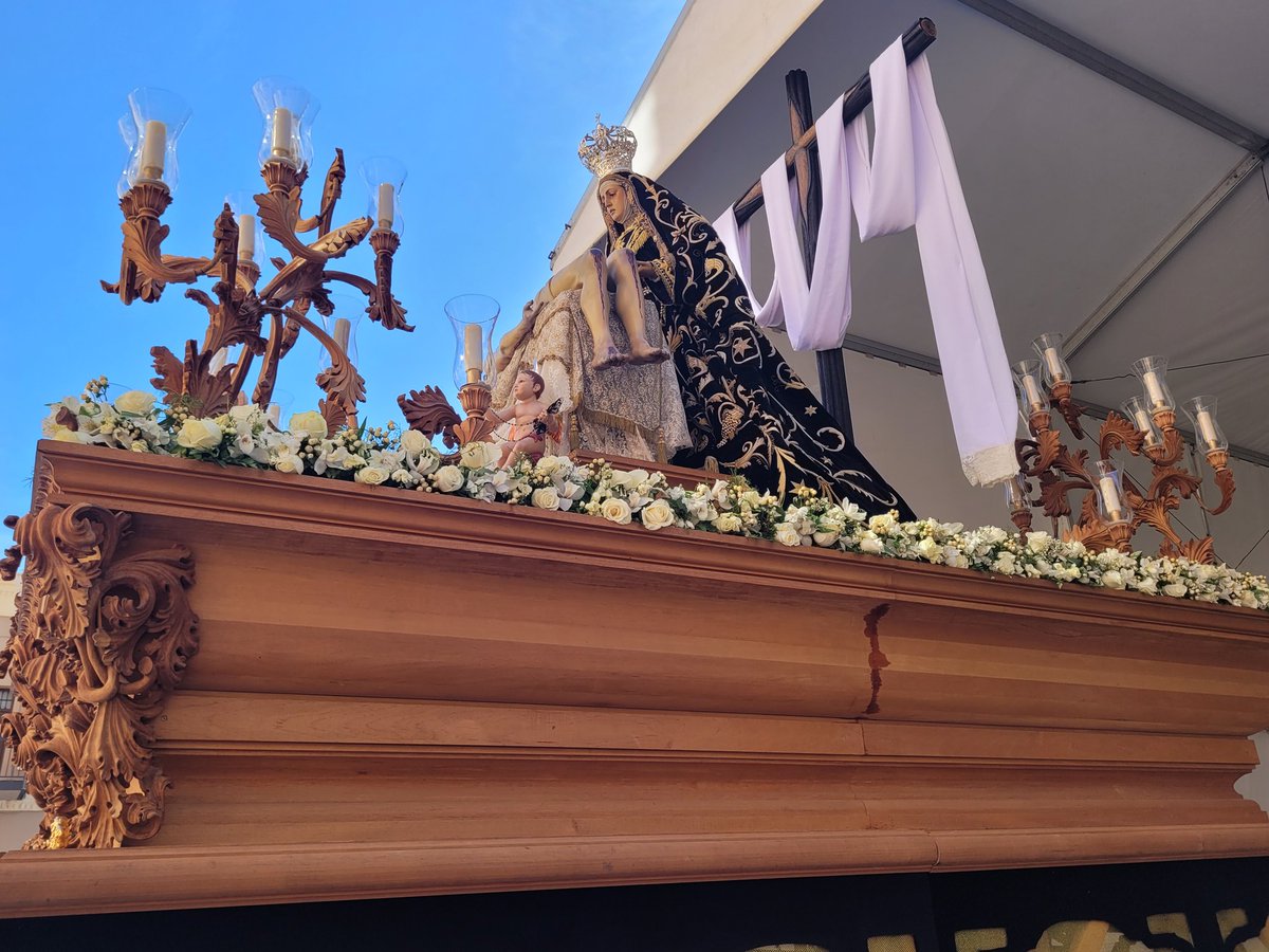 El exorno floral del paso de Nuestra Señora de las Angustias está compuesto por Rosa pitimini, orquídea, astromeria, frecsia, bouvardia, flor de cera, rosa, hyperycum y statice blanco, helecho, ruscus y pistacia