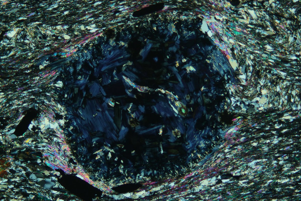 SpectrumPetro's tweet photo. Garnet porphyroblast replaced by pennanite (blue in XPL and green in PPL) with relic radioactive mineral damage (dark spots).

#spectrumpetro #thinsectionthursday #thinsection #geology #mineralogy #science #nature #Minerals #mineral #science #rocks #petrography https://t.co/48lZnY7CsX