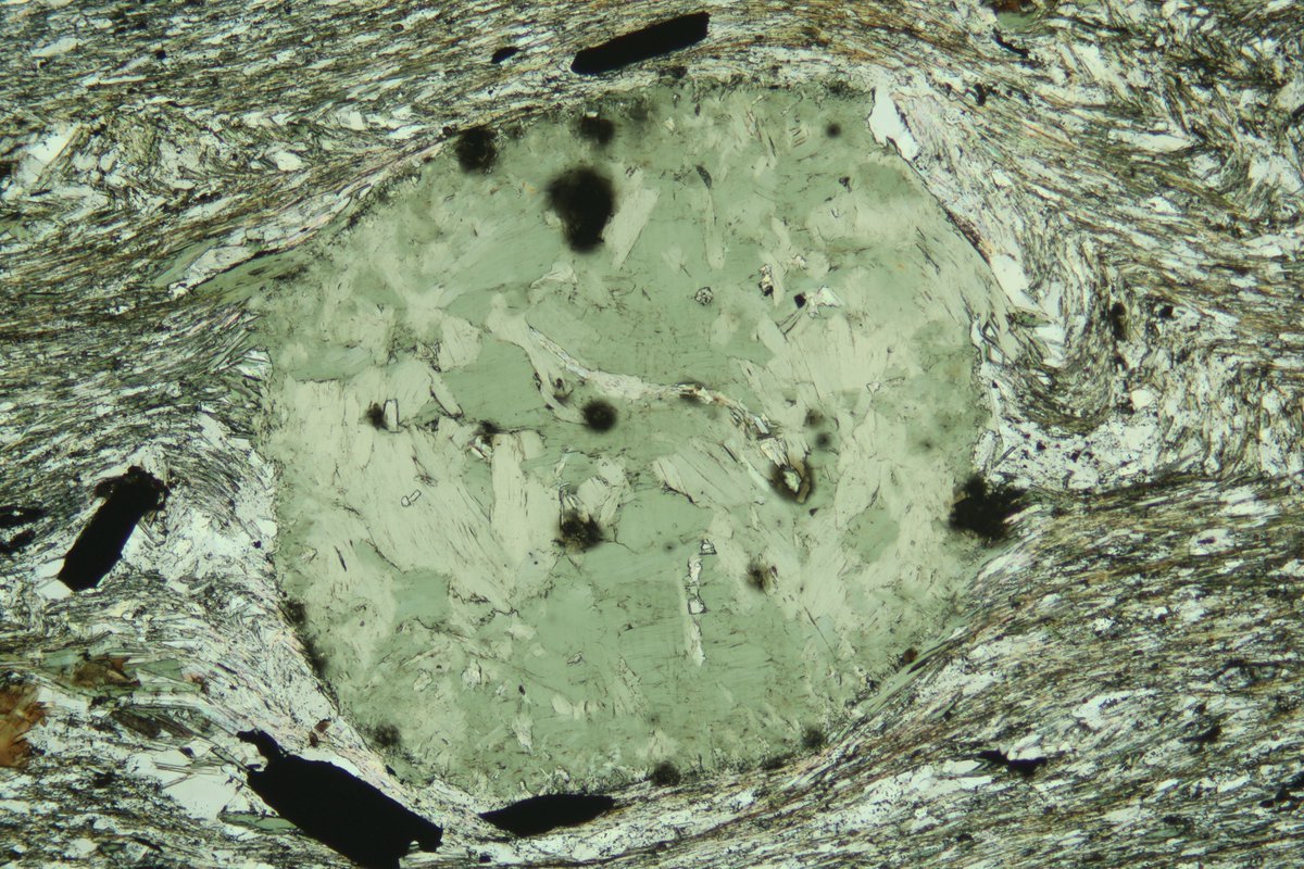 SpectrumPetro's tweet photo. Garnet porphyroblast replaced by pennanite (blue in XPL and green in PPL) with relic radioactive mineral damage (dark spots).

#spectrumpetro #thinsectionthursday #thinsection #geology #mineralogy #science #nature #Minerals #mineral #science #rocks #petrography https://t.co/48lZnY7CsX