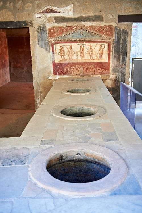 archeohistories's tweet photo. Thermopolium of Lucius Vetutius Placidus on Via del Abbondanza with serving counter with holes that contained amphora of food for sale. 

Thermopolium was an eating &amp; drinking house.

Pompeii (1st Century BC)

#archaeohistories https://t.co/j4TpMqCVpc