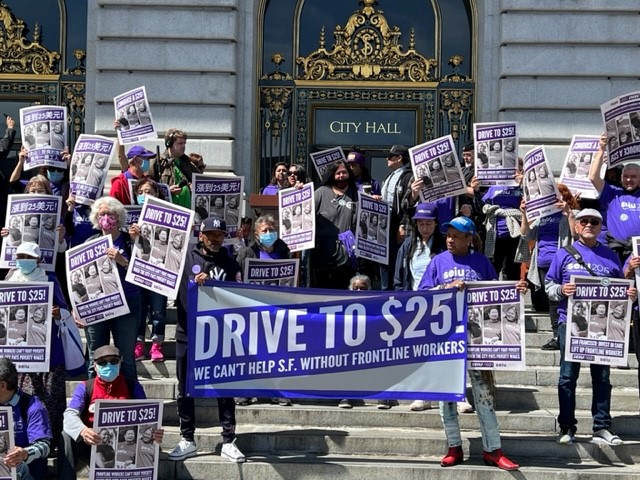 SEIU2015's tweet photo. 💥 HAPPENING NOW! 💥 EVP @KimEvonSEIU2015 and member leader Delmy Campos rally members along with our sister union @SEIU1021 in front of San Francisco City Hall! Workers providing essential human services demand $25/hour for ALL healthcare workers in SF! #PutCareFirst #DriveTo25 https://t.co/wFqSC41E1r
