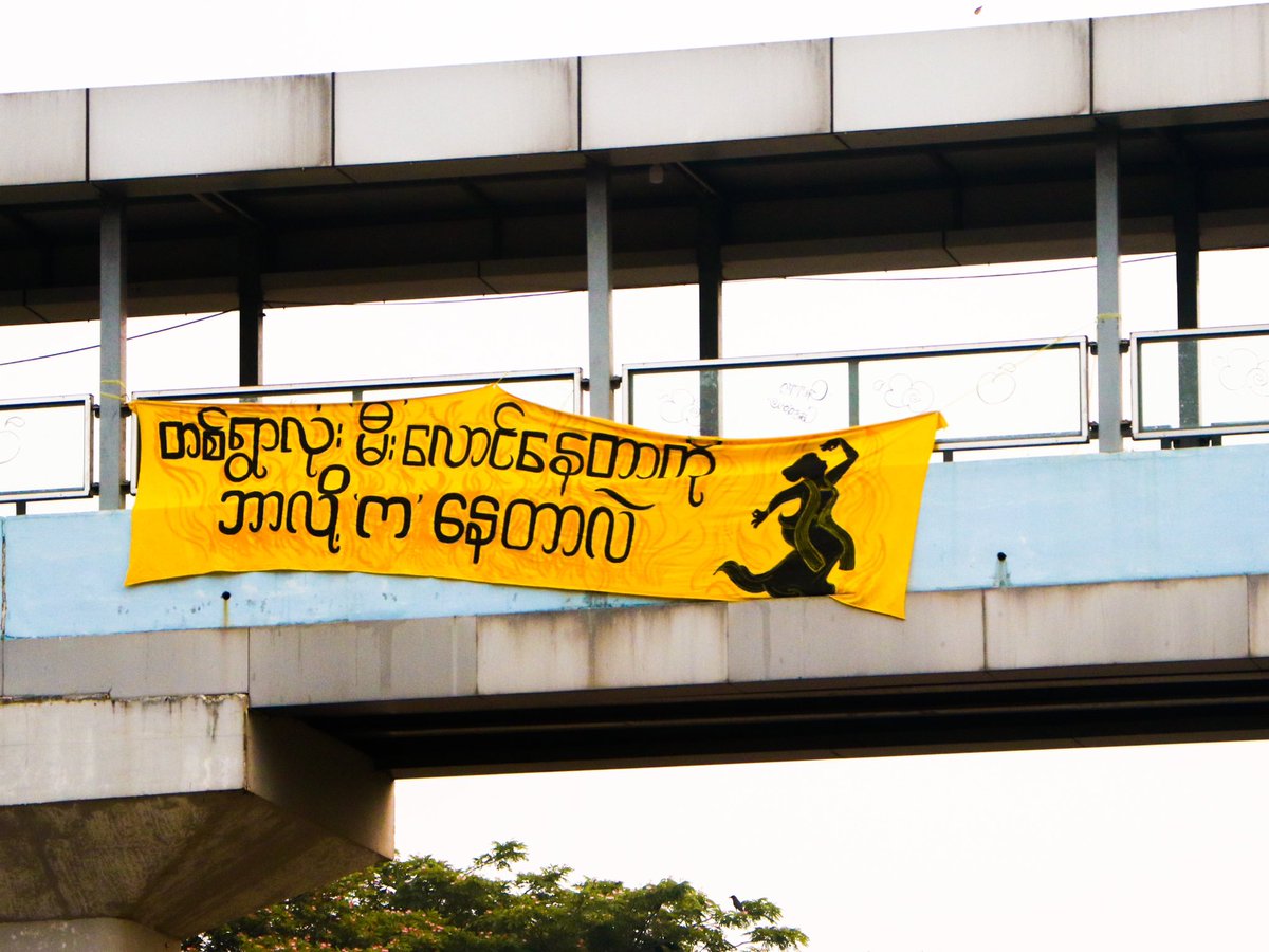 This morning in Yangon, young comrades of Yangon Revolution Force - YRF Soft Strike Community hanged a banner which said “Why Are You Dancing When The Whole Village Is Burning?”. #WhatsHappeingInMyanmar #yangonrevolutionforce #YRF