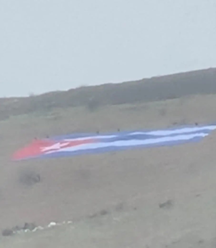 ElNecio_Cuba's tweet photo. Joe Biden llegó hoy a Irlanda del Norte. En una colina próxima al aeropuerto donde aterrizó desplegaron esta enorme bandera que seguramente vio desde su ventanilla 🇨🇺 Los irlandeses fueron a recordarle que también ellos están con Cuba, la isla que mantiene bloqueada. Me imagino su cara al ver esta escena 😬

📣 @hacthoun