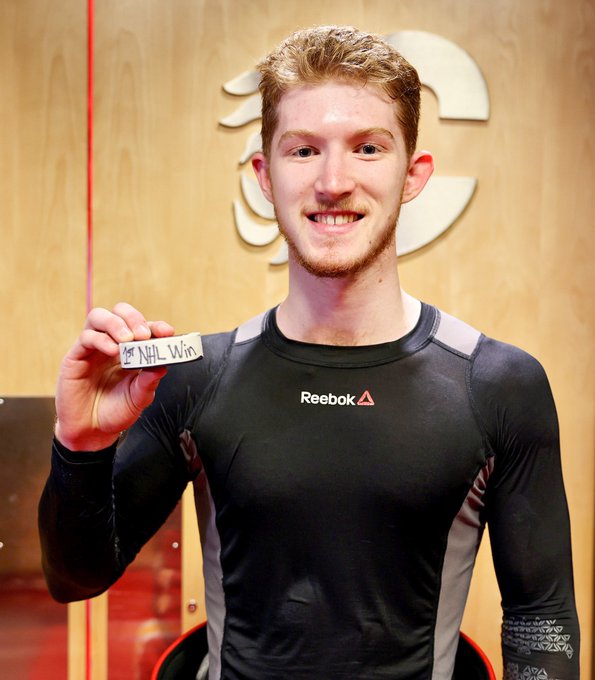Dustin Wolf holding the puck from his first win