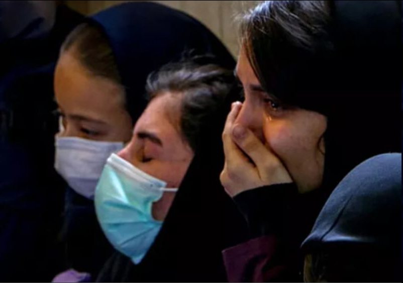 Rev_Group_iran's tweet photo. ارسالی یکی از دانش‌آموزان درگیر عوارض #حمله_شیمیایی. اطلاعات هویتی ایشان حذف شده.

اسفندماه سال ۱۴۰۱ با حمله شیمیایی که به مدرسه‌مون شد مسموم شدم و هنوز بعد از گذشت تقریبا دو ماه خوب نشدم.
من تو مدرسه ... شهر ... درس میخونم. مدرسه ما دو طبقه مجزا داره. اون روز دانش‌آموزایی که طبقه بالا درس می‌خوندن ساعت ۹ صبح میرن پیش مدیر مدرسه و بهش میگن که بعضی‌ها سرگیجه و سردرد دارن و بوی خیلی بدی تو کلاس‌ها پیچیده. اما مدیر از زنگ زدن به والدین یا پیگیری کردن ماجرا خودداری می‌کنه و با گفتن اینکه به خودتون تلقین می‌کنین و چیزیتون نیست و ادا درمیارید تا بگید مثل بچه‌های قم و تهران گاز گرفته‌تون قضیه رو می‌پیچونه.

ساعت ۱۲ ظهر تو مدرسه زنگ خطر اعلام شد و با میکروفن اعلام کردن که کسی نباید تو کلاس‌ها بمونه و همه باید خارج بشن ولی دبیران تمام بچه‌ها رو ده دقیقه بیشتر و به زور سر کلاس‌ها نگه داشتن و تا وقتی که خودمون فرار نکردیم اجازه خروج بهمون ندادن.
من به شخصه اونقدر حالم بد نبود اما وقتی دبیر نذاشت بریم بیرون تو اون ده دقیقه دچار کمی احساس تهوع و سرگیجه شدم که بهش توجهی نشون نمی‌دادم.
وقتی به حیاط رسیدم متوجه شدم حدود سی نفر از بچه‌ها غش می‌کنن و نفس‌شون به زور بالا میاد.
مدیر مدرسه با دیدن این حالات بچه‌ها می‌ترسه و زنگ می‌زنه به والدین تا بیان و بچه‌هاشون رو جمع کنن ببرن.
پدر یکی از بچه‌ها همون نزدیکیاست و خودشو خیلی سریع به مدرسه می‌رسونه.
با دیدن حال بچه‌ها فورا به آمبولانس زنگ میزنه و اطلاع گاز گرفتی مدرسه رو میده.
با اومدن آمبولانس جو مدرسه متشنج می‌شه و بقیه بچه‌ها که سالم هستن برای دوستاشون که پرپر می‌شن گریه و بی‌قراری می‌کنن. به همین دلیل مدیر و معاون کسایی که سالم بودن رو به بیرون مدرسه می‌فرستن و می‌گن که بریم خونه‌هامون.

جلو در مدرسه وایساده بودیم که از بالای پل یه چیزی پرت شد جلو در مدرسه.
ما چون تمام حواس‌مون به دوستامون و اتفاقای افتاده بود، اطلاعی از اینکه کی یا چی ترکوندن نداشتیم، ولی صدای انفجار اونقدر بلند بود که انگار زمین زیر پامون با انفجارش لرزید. بعد از ترکیدنش یه دود زرد و قهوه‌ای رنگ ازش بیرون اومد و به قدری زیاد بود که تقریبا تمام هوای محیط مدرسه رو درگیر کرد.
یادمه که دوستام خیلی ترسیده بودن و داشتن گریه ��ی‌کردن. من با دوبار تنفس اون گاز احساس گیجی بهم دست داد و حس می‌کردم ریه‌هام دارن آتیش می‌گیرن. فقط تونستم به دوستام بگم حالم خوب نیست و اونا فکر کردن شوخی می‌کنم و با گریه خواهش می‌کردن ادا درنیارم. ولی وقتی هوشیاریم پایین اومد و نفس‌هام منقطع شد فهمیدن جدا حالم بده و من هم درگیر شدم.

می‌تونستم صدای جیغ و فریادشون که اسممو می‌گفتن بشنوم اما قدرت اینکه بهشون جواب بدم یا عکس‌العملی نشون بدم رو نداشتم. می‌فهمیدم دورم چه خبره و دارن به آمبولانس منتقلم می‌کنن اما اون لحظه گاز روم تاثییر گذاشته بود و تمام بدنم سر شده بود. نفس‌هام به زور از ریه‌ام خارج می‌شدن و اصلا کنترلی رو بدنم نداشتم. در حدی بود که وقتی آمبولانس راه افتاد و ماشین تکون می‌خورد با هر تکون کوچیکی به یه طرف می‌افتادم و نمی‌تونستم حتی تلاشی برای نگه داشتن خودم روی صندلی بکنم.

بعد از اینکه به بیمارستان رسیدیم با برانکارد به اورژانس منتقل‌مون کردن و همون اول ازمون آزمایش خون گرفتن و ماسک اکسیژن و سرم برامون وصل کردن. بعد گذشت حداقل یک ساعت کمی هوشیاریم برگشت و تونستم تشخیص بدم که دانش‌آموزای مدرسه... که مسموم شدن تعدادشون ۱۰۷ نفره و اونقدر بچه‌ها زیادن که اونا رو برای درمان کف اورژانس دراز کردن و بهشون رسیدگی می‌کنن.
بعد یک ساعت حس خوا��‌آلودگی شدیدی بهم دست داد و اصلا نمی‌تونستم خودمو در برابر خواب کنترل کنم. خانواده‌ام نگران شدن و دکتر رو خبر کردن. دکتر اورژانس با نیشگون گرفتن و سیلی زدن مجبورم کرد که بیدار بمونم.

من و ۱۸ نفر دیگه که حال‌مون خیلی وخیم بود رو بستری کردن و بقیه رو سرسری مرخص کردن اما غروب که شد حدود ۵۰ نفر دوباره به بیمارستان مراجعه کردن و گفتن تو خونه دوباره حالشون بد شده.
قرار به این شد که فردا من و کسایی که بستری بودیم مرخص بشیم اما نصفه شب احساس کردم تمام بدنم سر شده. حتی نمی‌تونستم انگشتام رو تکون بدم. هیچ جای بدنم حس نداشت و تماما سر شده بود. اون لحظات واقعا ترسیده بودم. می‌ترسیدم که نکنه تا آخر عمر اینجوری بمونم و نتونم دست و پامو تکون بدم. حس مرگ می‌کردم. پرستارها و دکترا اومدن و با گفتن اینکه چیزی نیست اثرات استرس و اضطرابه سرمون رو شیره مالیدن و رفتن.
تا دم صبح حس سری از بدنم بیرون نرفت.۱/۲

#IranChemicalAttacks