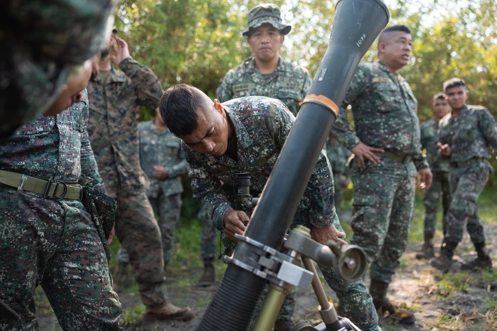 3d_Marine_Div's tweet photo. Our #Marines with 3d Littoral Combat Team, 3d Marine Littoral Regiment, alongside members of the Philippine Marine Corps conduct bilateral weapons familiarization with an M252 81 mm mortar system during Balikatan 23 in Santa Juliana, Philippines. https://t.co/01KA2OKSE2