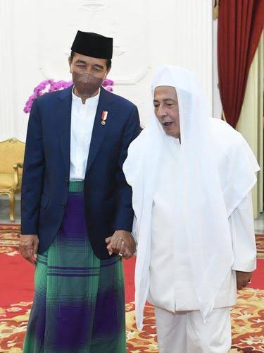 LiterasiRakyat's tweet photo. Siapa bilang saya tidak menjawab, ?, justru saya menjawab pertanyaan anda karena santun dalam menyampaikan komentar.
Ini sekaligus sebagai klarifikasi atas ribuan akun yang langsung saya blokir karena sudah bodoh, tak berahlak pula.

Saya coba jawab ya.
Supaya anda memahami dinamika politik yg terjadi dimasa kolonial Belanda menjadi rezim penguasa di negeri ini dulu, maka akan saya berikan sedikit gambaran tentang keadaan pada rezim dimasa kini.

Sebenarnya anda tak perlu terjebak  dengan fakta sejarah bahwa Habib Usman bin Yahya ditunjuk sebagai Mufti Batavia oleh Ratu Wilhelmina, mengapa..?
Anda kenal Habib Lutfi bin Yahya..?

Beliau adalah salah satu Habaib yang berada dalam lingkaran rezim saat ini. Beliau diangkat sebagai Anggota Dewan Pertimbangan Presiden. Padahal dimasa rezim saat ini kalangan Habaib di diskreditkan sedemikian rupa seakan-akan mereka adalah ekstrem kanan yang harus diwaspadai, intoleran, radikal, anti NKRI, dstnya dstnya.

Apakah Habib Lutfi bin Yahya disebut pengkhianat oleh para habaib lainnya yang berada diluar lingkaran rezim dan kelompok oposisi pemerintah..?. TIDAK..!!.

Anda tau mengapa..? 
Karena umat yang ta’dzim pada para Habaib dan Ulama itu tau dan sadar sesadar-sadarnya, bahwa keberadaan Habib Lutfi, perjuangannya, tindakan dan pikiran-pikirannya dalam lingkaran kekuasaan politik rezim telah menyelamatkan banyak hal buruk yang mungkin bisa terjadi pada bangsa dan negara ini.

Anda bisa melihat bagaimana polarisasi didesign sebegitu sistematisnya agar antara habaib dengan Nahdlatul Ulama dan organisasi-organisasi underbownya saling dibenturkan, diadu agar saling membenci satu dng lainnya.

Apa yang terjadi jika Habib Lutfi tidak berada disana…?
Tak perlu menunggu September untuk bilang bahwa kekuatan-kekuatan tanpa entitas Komunis dan Liberal akan bertepuk tangan menikmati baku hantam antar umat yang terjadi.

Mereka yang menuduh rezim ini dikuasai kelompok pro komunis sekalipun tak berani mengatakan Habib Lutfi menjadi pengkhianat karena membela kepentingan rezim, apalagi melabel sebagai pro komunis. Sekalipun beliau diberi Penghargaan, Gaji dan Jabatan dari rezim berkuasa.

Lalu mengapa untuk fenomena masa lalu dan masa kini yang nyaris serupa itu oleh pihak tertentu disikapi berbeda..?

Apakah mereka tak menyadari atau setidaknya memahami bahwa fenomena Habib Usman bin Yahya dimasa lalu lebih kurangnya mirip dengan fenomena Habib Lutfi di masa kini..?

Sebenarnya tau dan paham, namun syahwat politik kedengkian lebih mewarnai pikiran-pikiran kotor mereka terhadap kalangan Habaib.
Mereka jadikan fenomena-fenomena tersebut sebagai amunisi untuk menebar citra buruk pada habaib yang tidak kecil andilnya pada perjuangan kemerdekaan negeri ini.

Pada setiap masa, akan ada saja pandangan dan ijtihad dari kalangan ulama atau habaib yang membuat penguasa tersenyum karena merasa diuntungkan, namun bukan karena ijtihad mereka dibeli.

Habib Jindan bin Novel bin Jindan dalam sebuah ceramahnya pernah mengatakan, “Dakwah dengan cara menebar caci maki bukankah dakwah yang dicontohkan Nabi Muhammad SAW”. 
Hal yang sama juga terjadi kala Al-Habib Ali Aljufri menyampaikan fatwa bolehnya mengucapkan “Selamat Natal”.

Apa yang disampaikan keduanya tentu saja membuat kelompok Pro Liberal tersenyum gembira dan para pengasong radikal-radikul berjingkrakan.

Apakah kedua Habaib tersebut “dibeli” oleh penguasa ? Tidak.
Walaupun pendapat keduanya mungkin saja berbeda dengan pendapat jumhur ulama atau mayoritas habaib lainnya.

Pada dasarnya, propaganda kedengkian dan kebencian harus dilawan dengan kontra narasi yang mencerdaskan dan membuka wacana berpikir umat, karena jika umat yang sadar diam, maka kesesatan berpikir akan ditelan bulat-bulat oleh umat yg lengah dan dianggap sebagai sebuah kebenaran yang pantas diterima.

Retweet jika anda setuju!.