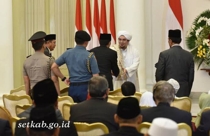 LiterasiRakyat's tweet photo. Siapa bilang saya tidak menjawab, ?, justru saya menjawab pertanyaan anda karena santun dalam menyampaikan komentar.
Ini sekaligus sebagai klarifikasi atas ribuan akun yang langsung saya blokir karena sudah bodoh, tak berahlak pula.

Saya coba jawab ya.
Supaya anda memahami dinamika politik yg terjadi dimasa kolonial Belanda menjadi rezim penguasa di negeri ini dulu, maka akan saya berikan sedikit gambaran tentang keadaan pada rezim dimasa kini.

Sebenarnya anda tak perlu terjebak  dengan fakta sejarah bahwa Habib Usman bin Yahya ditunjuk sebagai Mufti Batavia oleh Ratu Wilhelmina, mengapa..?
Anda kenal Habib Lutfi bin Yahya..?

Beliau adalah salah satu Habaib yang berada dalam lingkaran rezim saat ini. Beliau diangkat sebagai Anggota Dewan Pertimbangan Presiden. Padahal dimasa rezim saat ini kalangan Habaib di diskreditkan sedemikian rupa seakan-akan mereka adalah ekstrem kanan yang harus diwaspadai, intoleran, radikal, anti NKRI, dstnya dstnya.

Apakah Habib Lutfi bin Yahya disebut pengkhianat oleh para habaib lainnya yang berada diluar lingkaran rezim dan kelompok oposisi pemerintah..?. TIDAK..!!.

Anda tau mengapa..? 
Karena umat yang ta’dzim pada para Habaib dan Ulama itu tau dan sadar sesadar-sadarnya, bahwa keberadaan Habib Lutfi, perjuangannya, tindakan dan pikiran-pikirannya dalam lingkaran kekuasaan politik rezim telah menyelamatkan banyak hal buruk yang mungkin bisa terjadi pada bangsa dan negara ini.

Anda bisa melihat bagaimana polarisasi didesign sebegitu sistematisnya agar antara habaib dengan Nahdlatul Ulama dan organisasi-organisasi underbownya saling dibenturkan, diadu agar saling membenci satu dng lainnya.

Apa yang terjadi jika Habib Lutfi tidak berada disana…?
Tak perlu menunggu September untuk bilang bahwa kekuatan-kekuatan tanpa entitas Komunis dan Liberal akan bertepuk tangan menikmati baku hantam antar umat yang terjadi.

Mereka yang menuduh rezim ini dikuasai kelompok pro komunis sekalipun tak berani mengatakan Habib Lutfi menjadi pengkhianat karena membela kepentingan rezim, apalagi melabel sebagai pro komunis. Sekalipun beliau diberi Penghargaan, Gaji dan Jabatan dari rezim berkuasa.

Lalu mengapa untuk fenomena masa lalu dan masa kini yang nyaris serupa itu oleh pihak tertentu disikapi berbeda..?

Apakah mereka tak menyadari atau setidaknya memahami bahwa fenomena Habib Usman bin Yahya dimasa lalu lebih kurangnya mirip dengan fenomena Habib Lutfi di masa kini..?

Sebenarnya tau dan paham, namun syahwat politik kedengkian lebih mewarnai pikiran-pikiran kotor mereka terhadap kalangan Habaib.
Mereka jadikan fenomena-fenomena tersebut sebagai amunisi untuk menebar citra buruk pada habaib yang tidak kecil andilnya pada perjuangan kemerdekaan negeri ini.

Pada setiap masa, akan ada saja pandangan dan ijtihad dari kalangan ulama atau habaib yang membuat penguasa tersenyum karena merasa diuntungkan, namun bukan karena ijtihad mereka dibeli.

Habib Jindan bin Novel bin Jindan dalam sebuah ceramahnya pernah mengatakan, “Dakwah dengan cara menebar caci maki bukankah dakwah yang dicontohkan Nabi Muhammad SAW”. 
Hal yang sama juga terjadi kala Al-Habib Ali Aljufri menyampaikan fatwa bolehnya mengucapkan “Selamat Natal”.

Apa yang disampaikan keduanya tentu saja membuat kelompok Pro Liberal tersenyum gembira dan para pengasong radikal-radikul berjingkrakan.

Apakah kedua Habaib tersebut “dibeli” oleh penguasa ? Tidak.
Walaupun pendapat keduanya mungkin saja berbeda dengan pendapat jumhur ulama atau mayoritas habaib lainnya.

Pada dasarnya, propaganda kedengkian dan kebencian harus dilawan dengan kontra narasi yang mencerdaskan dan membuka wacana berpikir umat, karena jika umat yang sadar diam, maka kesesatan berpikir akan ditelan bulat-bulat oleh umat yg lengah dan dianggap sebagai sebuah kebenaran yang pantas diterima.

Retweet jika anda setuju!.