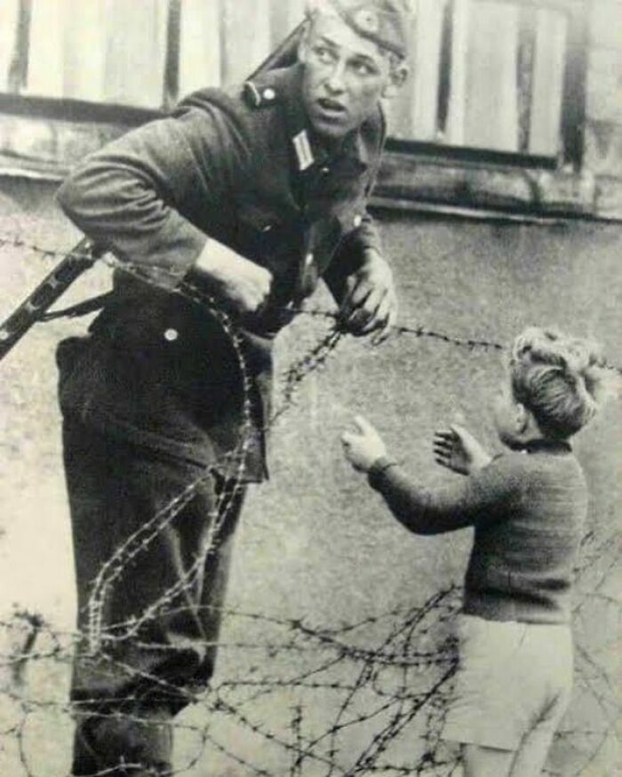 - Un soldado de Alemania Oriental ayudó a un niño pequeño a cruzar el Muro de Berlín el día en el que fue erigido, en 1961. El niño había sido dejado atrás debido al caos de gente que huyó para estar junto a sus familias en cada lado del muro