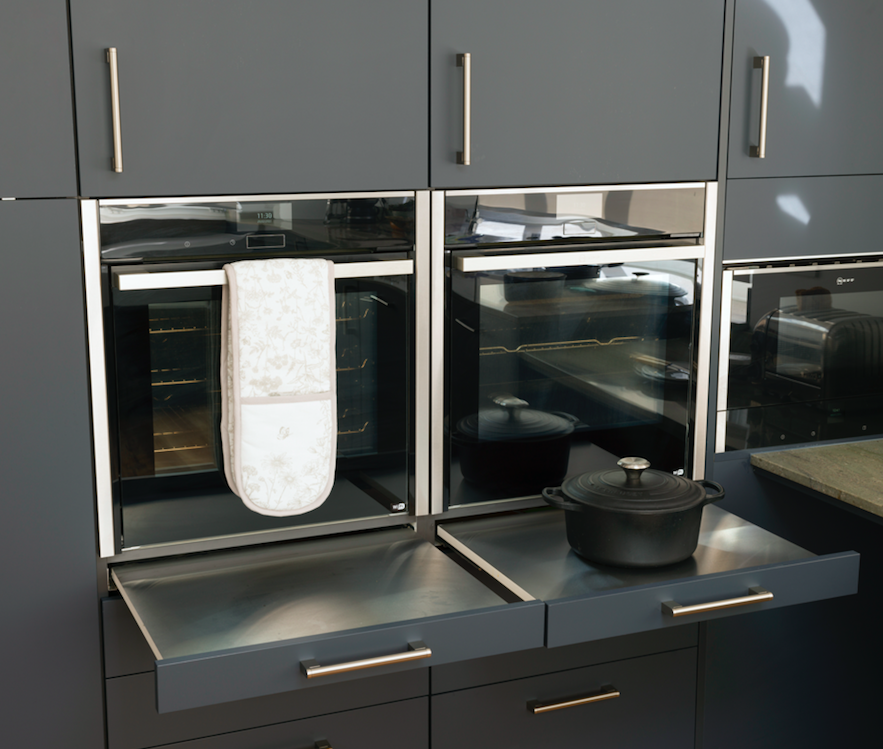 Perfect for those who like to entertain, these handy pull out shelves are heat resistant and allow you to rest hot food safely as it comes out of the oven. 

Kitchen Design by Tara Neil Kitchens and Adam Thomas