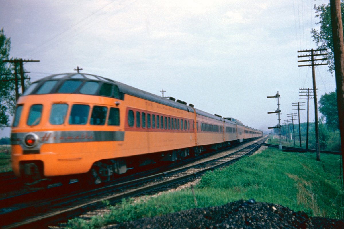 americanrails's tweet photo. In an era when fast service and the very best in accommodations was the norm, the Chicago - Twin Cities corridor offered several incredible trains.  One of the most famous was Milwaukee Road's Hiawathas.

When track conditions were still maintained to peak standards, these trains typically ran at speeds of 100 mph and could cover the 421 miles in just 6 1/2 hours.

Accommodations during the 1950s included reclining seat coaches, the famous Tip-Top-Tap buffet lounge, a full diner, a parlor car with a first-class drawing room, and the equally famous 'Skytop' lounge-observation.  Here Skytop Coon Rapids brings up the tail end of the Hiawatha near Portage, Wisconsin; May 23, 1953.

https://t.co/MXFlnaRzfo