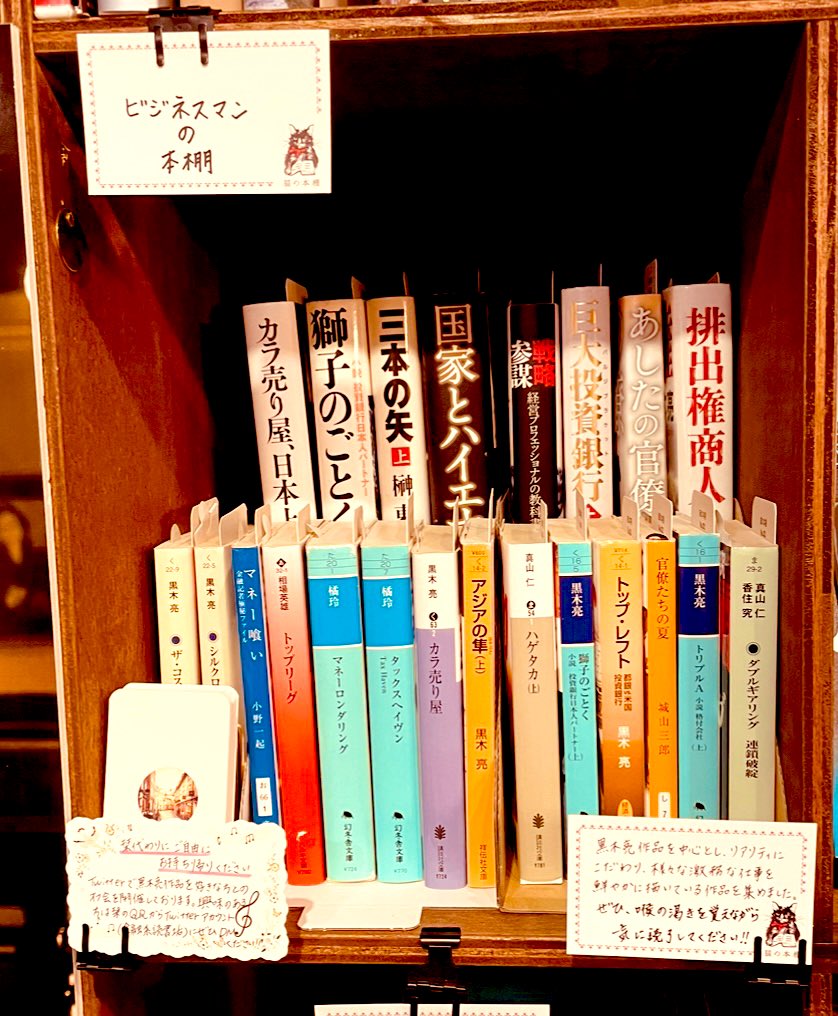 257110ma's tweet photo. 神保町「猫の本棚」@nekohon さんに、経済小説を基軸とした本棚をオープンすることが出来ました！

読書好きなら有名な神保町という街、そして、自分の知らない素晴らしい世界観で運営している「猫の本棚」さんで、ネットの世界には無い、本を通じてのローカルな接点が得られば幸いです。

@higuchism 
@MizunoMaya 
オーナー&棚主さまとの繋がりも楽しみにしております。茉莉花茶美味しかったです♪ありがとうございました。

@yamagatakouza 
隣の棚になりました！有名作家を続々と生み出している「山形小説家・ライター講座」さまの隣で嬉しいです！よろしくお願いいたします^_^