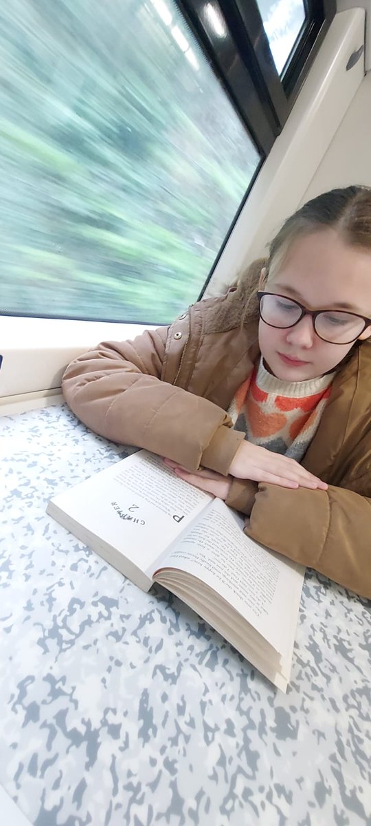 tracylovescake's tweet photo. @SandwichJunior Evie reading her book on the train to the Model Railway exhibition in Birchington today. https://t.co/rEUqq1VhSF