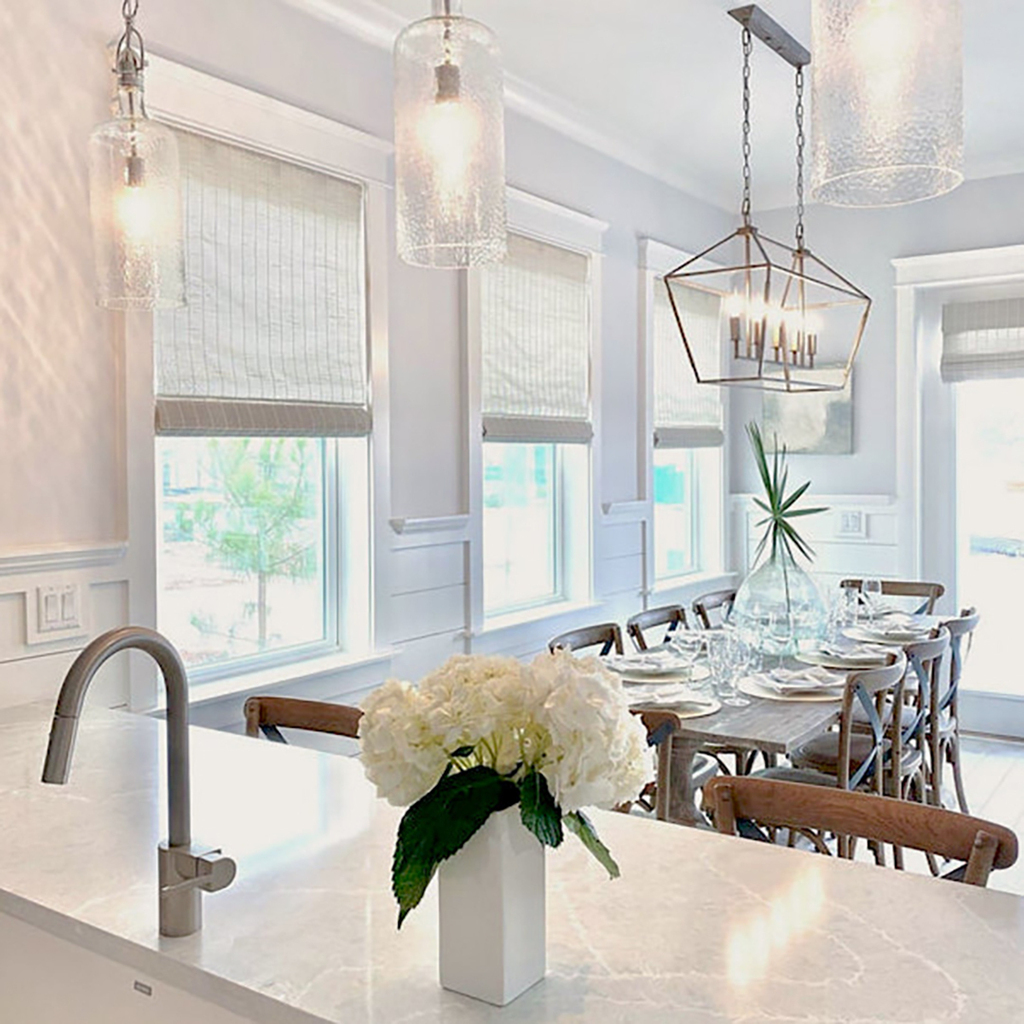 Create the cohesive kitchen and dining room you've always wanted with our woven wood shades. These high-functioning window coverings provide a soft finish in this space while filtering out light for any time of day! 📸: Budget Blinds of Destin &amp; Panama City Beach